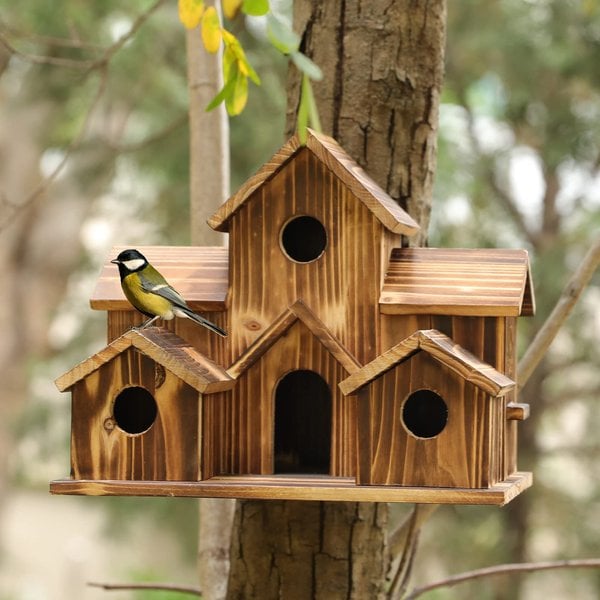 Wooden bird house showing arched entry holes and layered roof